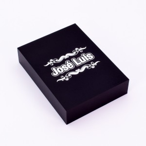 Detalle de grabado con greca en caja negra de madera